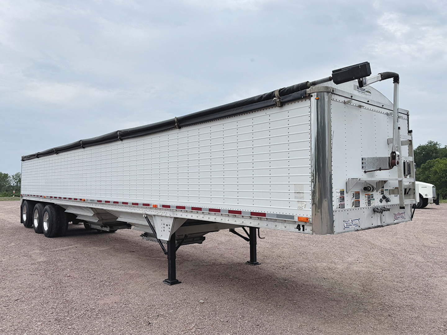 Trailer showing a 2008 Wilson Pacesetter hopper trailer with aluminum riveted sides, triple-axle configuration, and front-end landing gear visible.