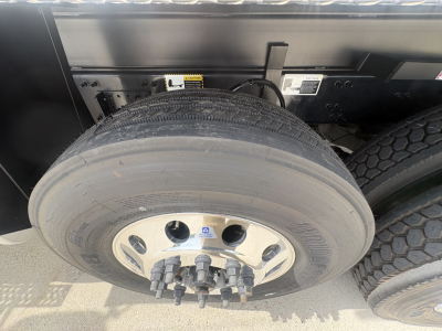 Mack GR84F wheel and tire mounted on rear axle showing alloy rim with lug nuts and dual rear tires in a truck bed area.