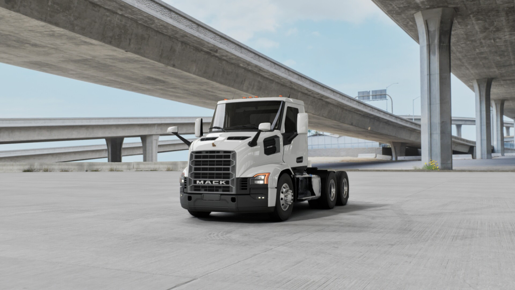 Mack AN64T conventional daycab truck under overpasses, front three-quarter view, with white cab and black grille.