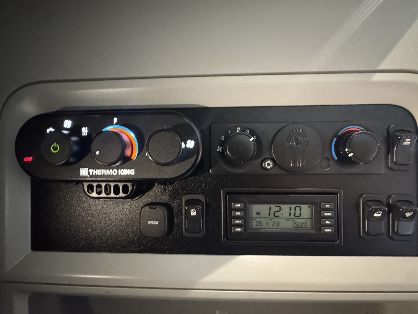 Kenworth T680 climate control panel and radio area with dashboard vents and digital clock display.