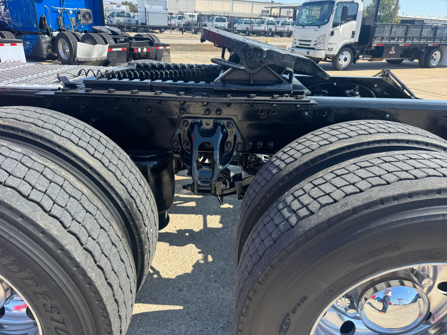 Kenworth T680 chassis showing dual rear axles and fifth wheel hitch with surrounding components.