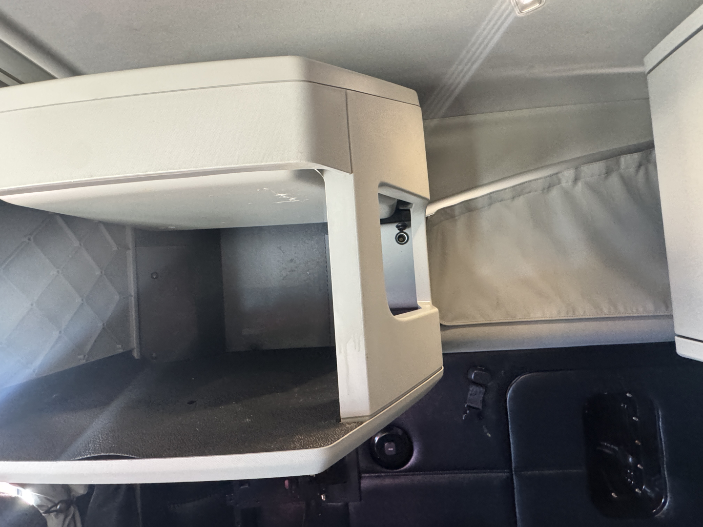 Kenworth T680 truck interior upper bunk/storage area and side panel with latch, light gray plastic cabinetry.