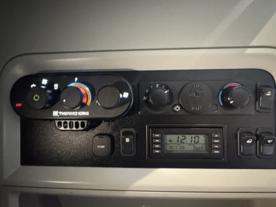 Kenworth T680 climate control panel and radio area with dashboard vents and digital clock display.