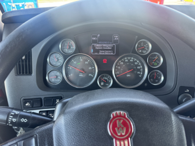 Kenworth T680 dashboard view showing instrument cluster and steering wheel with center display screen.