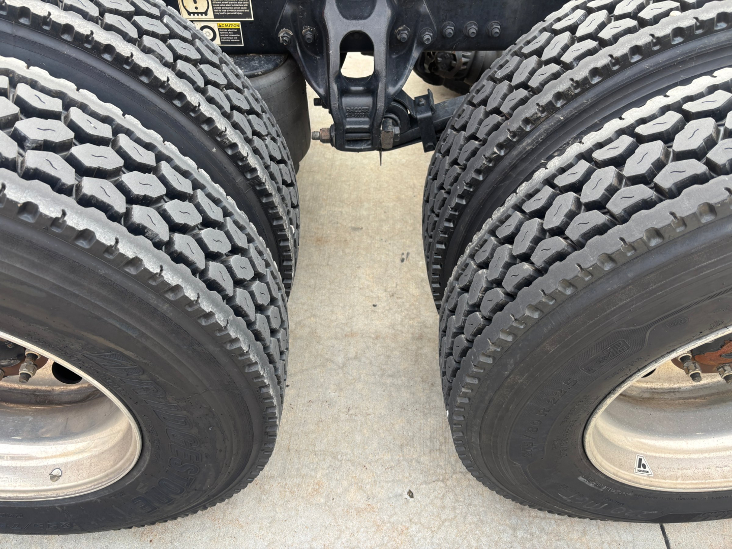 Kenworth T680 rear wheels and chassis showing dual rear axles and tires.