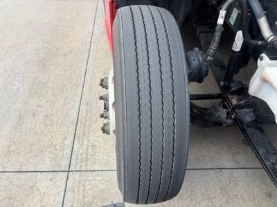 Kenworth T680 wheel and front suspension showing a single front tire and wheel hub.