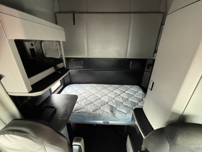 Kenworth T680 sleeper cab interior with bed platform visible and storage compartments.