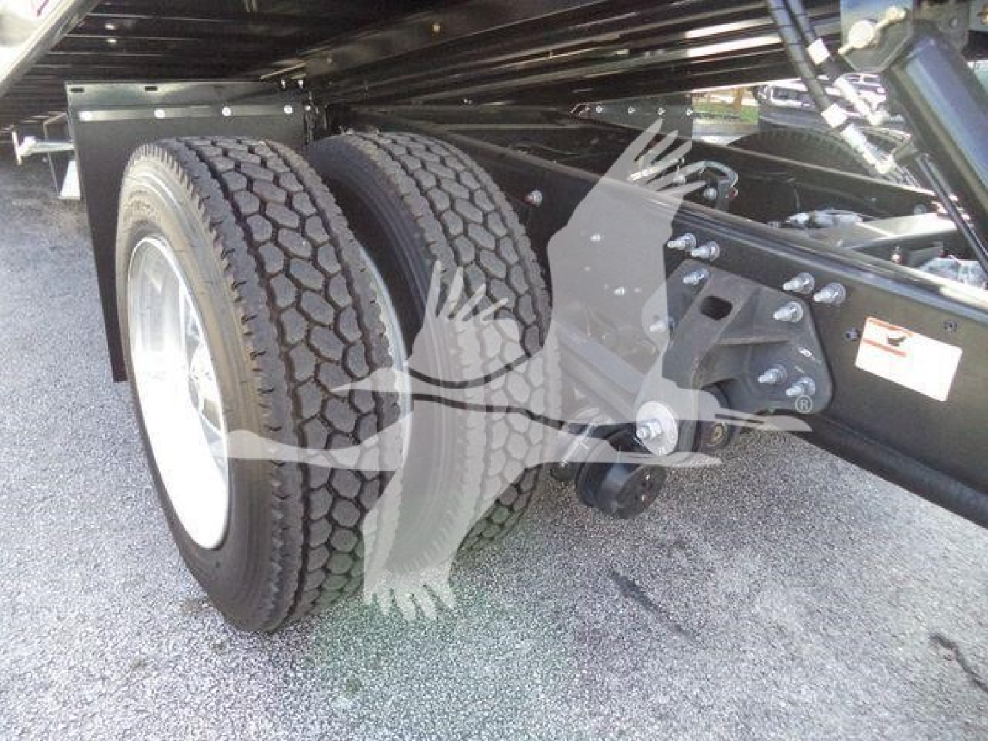 Dual rear axles and suspension under a 2025 Hino 268A rollback truck showing rear tires and suspension components.