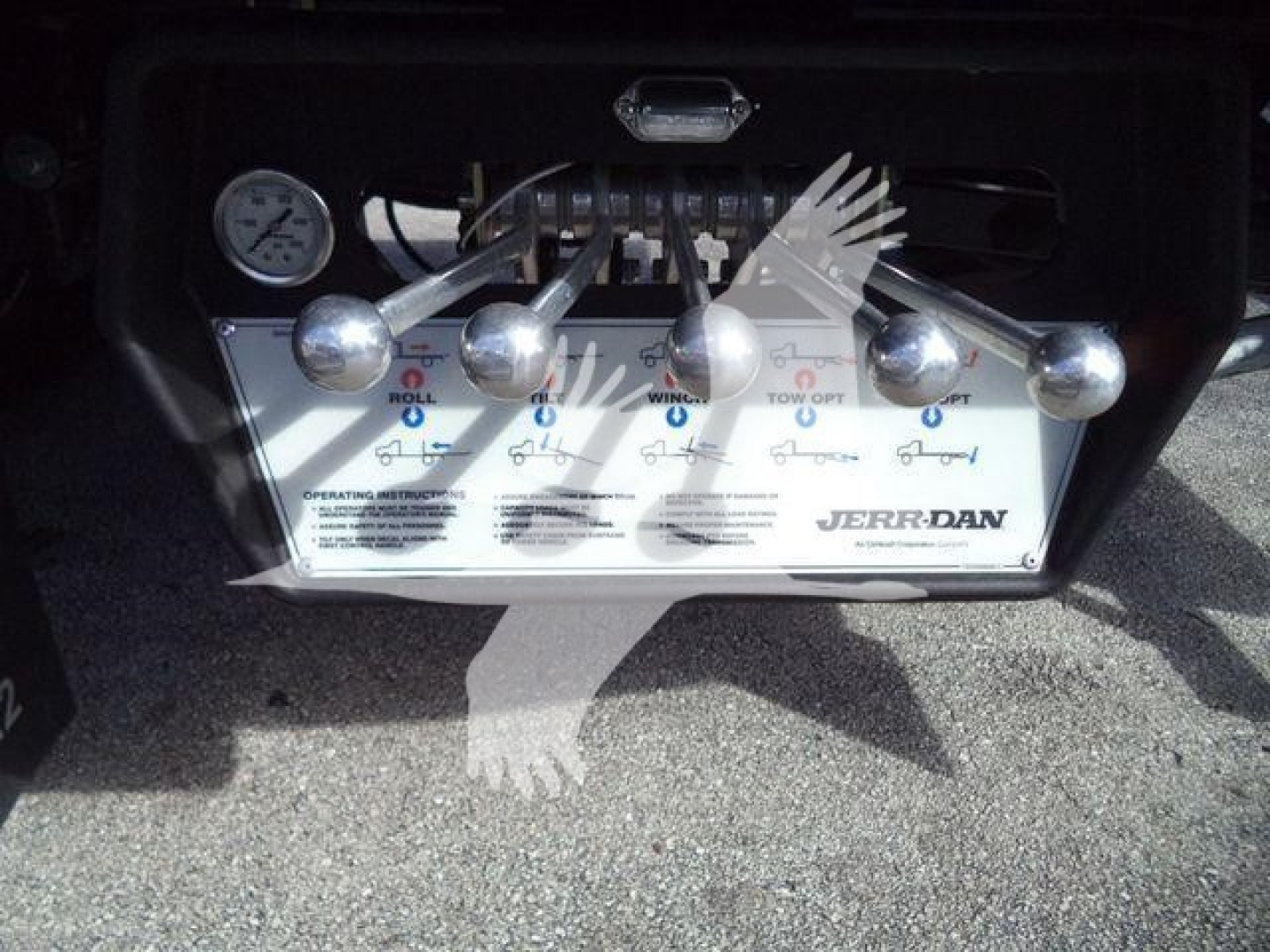 Panel with multiple chrome levers and a control diagram for a Hino 268A rollback truck, with gauges and a label showing JERR-DAN on the control panel.