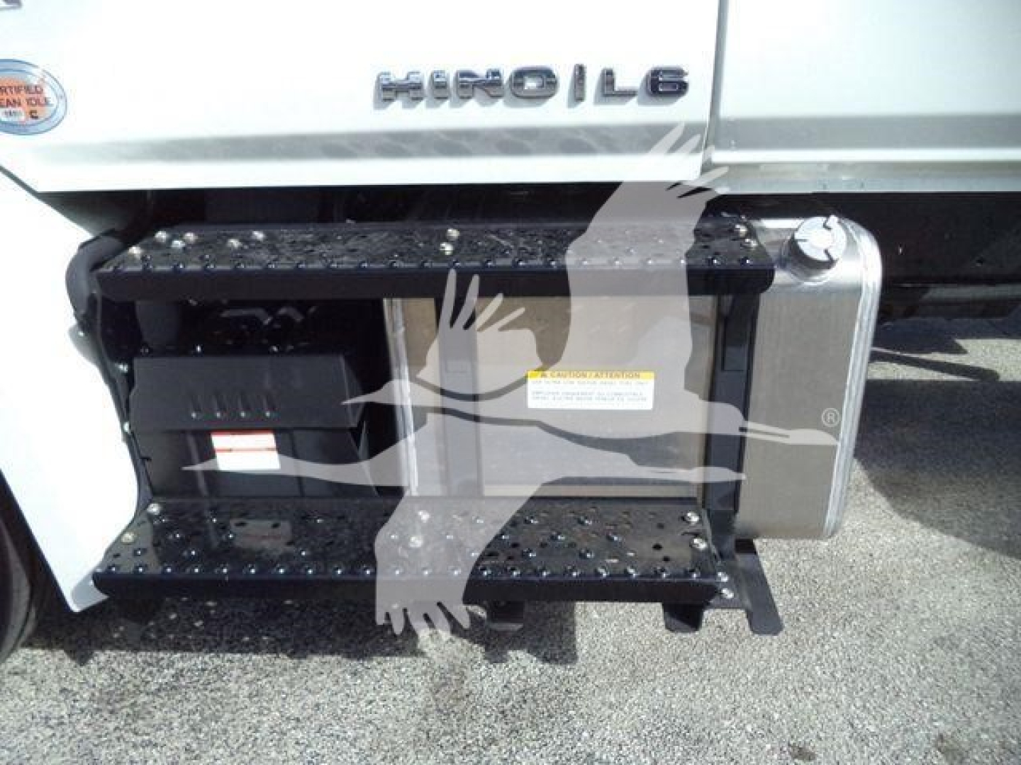 Hino 268A rollback truck side view showing fuel/air intake area, steps, and side storage tank.