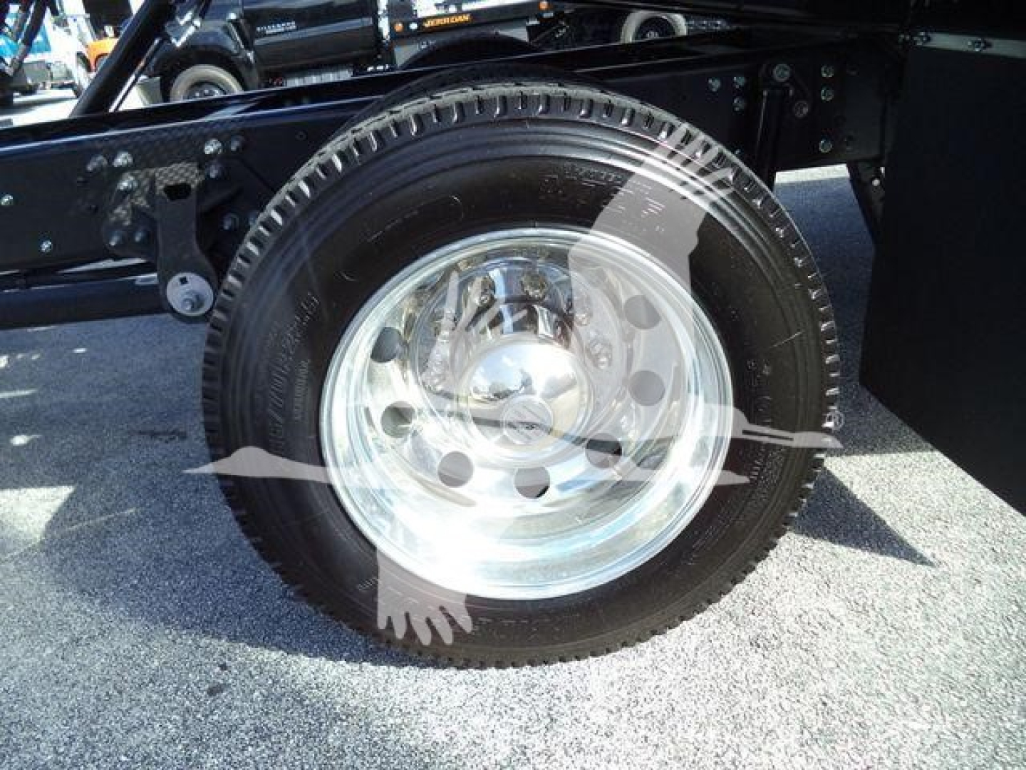 Wheel and tire close-up on a Hino 268A rollback truck showing polished steel rim and black tire.