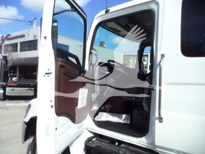 Truck cab interior and doorway of a 2025 Hino 268A roll-back truck showing open driver door and seating area