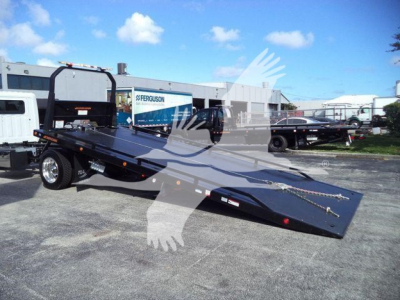 2025 Hino 268A rollback tow truck on lot with black ramp bed and equipment hitch.