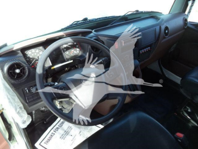 Dashboard and steering wheel view inside a 2025 Hino 268A cab showing instrument cluster and controls.