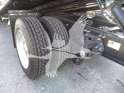 Dual rear axles and suspension under a 2025 Hino 268A rollback truck showing rear tires and suspension components.