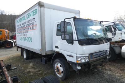 Box truck from side view showing cargo box with rental center signage and Ford cab; front wheel, bumper, and side mirror visible.