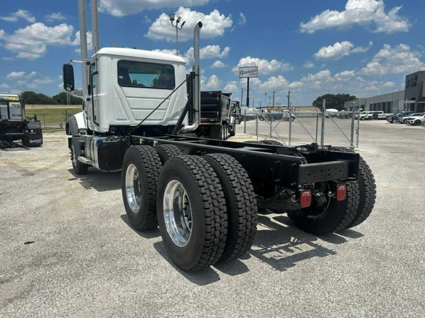 Mack GR64F cab and chassis showing dual rear axle and rear frame with tires and bumper.