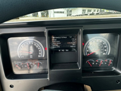 Dashboard of a 2027 Mack GR64F cab and chassis showing instrument cluster and central display with vehicle totals screen.