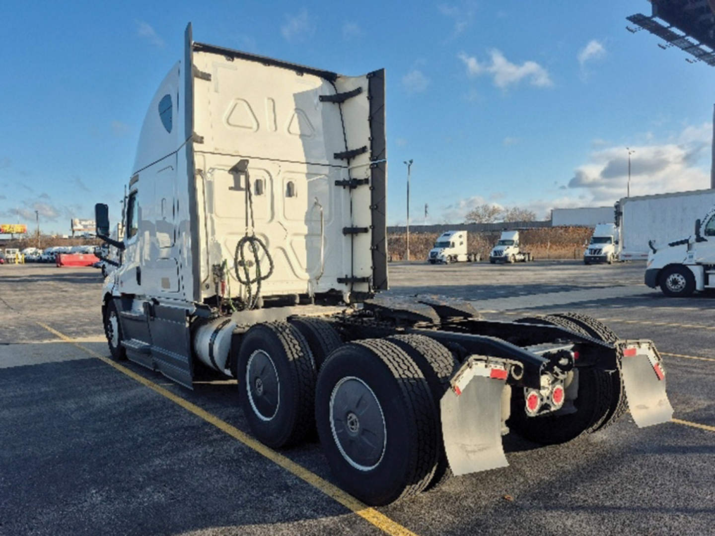 Truck chassis and cab of a Freightliner Cascadia126 tractor showing rear wheels and sleeper cab