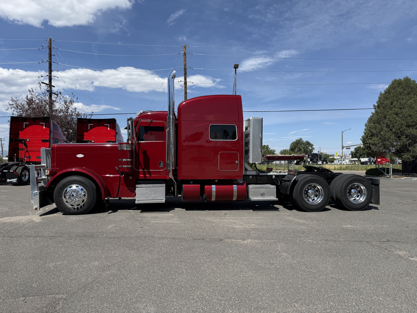 Peterbilt 389 conventional sleeper truck side view showing red cab and long chassis with twin rear axles.
