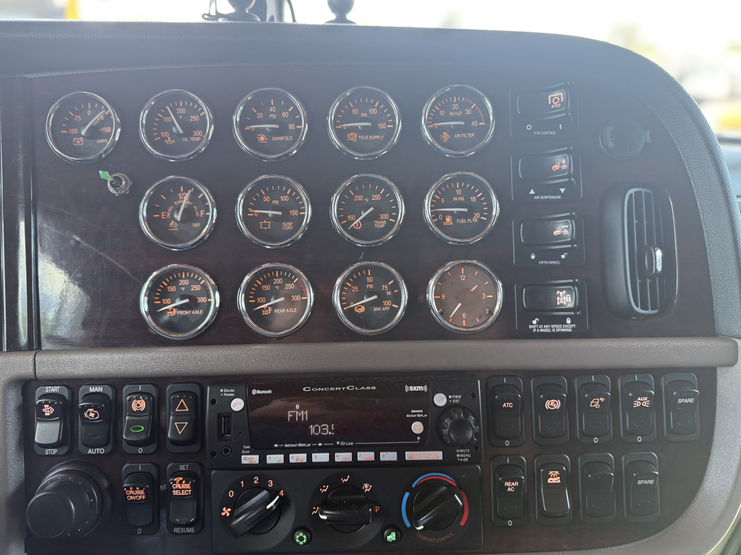 Peterbilt 389 dash panels showing multiple gauges and controls in a truck cab.