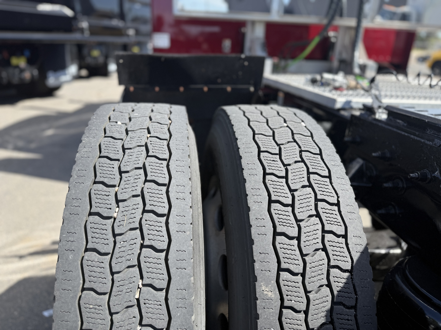 Two front tires of a Peterbilt truck chassis with tread pattern visible; no legible serials or labels in frame.
