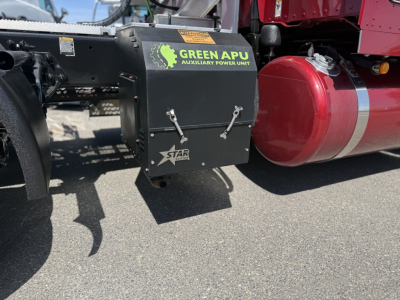 Peterbilt 389 chassis side showing Green APU auxiliary power unit and red cylindrical tank with black box and labels.