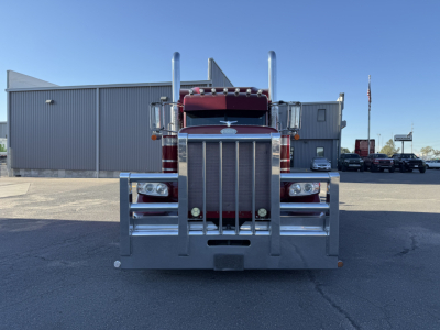 Peterbilt 389 front view showing large chrome grille, vertical exhaust stacks, and bumper guard.