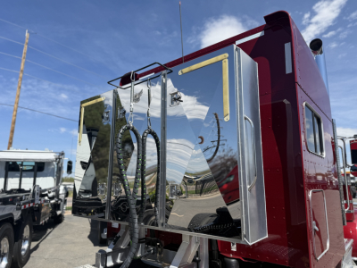 Peterbilt 389 conventional sleeper rear view showing polished stainless toolbox doors and chrome hoses.