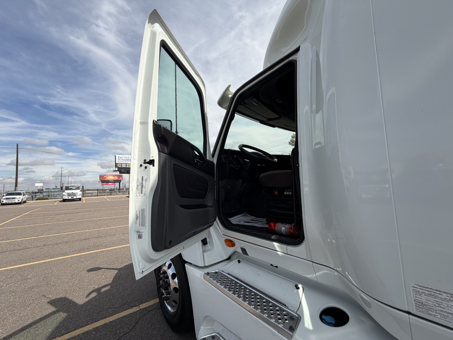 Truck cab with driver door open showing interior, steps, and white exterior of a 2019 International LT625.