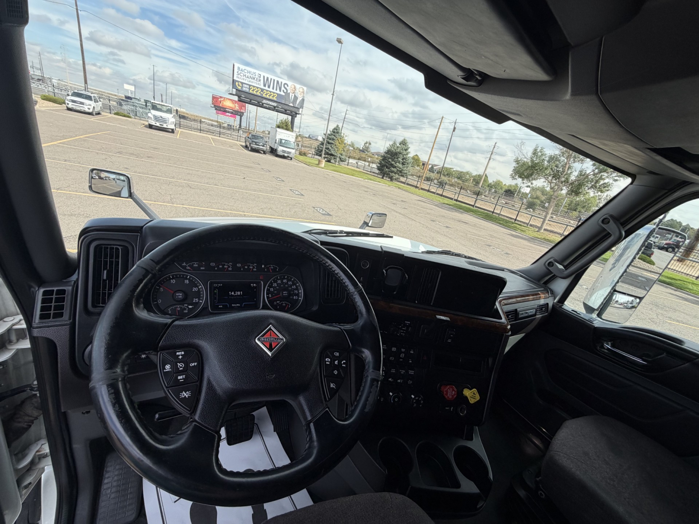 Truck cab interior of a 2019 International LT625 showing steering wheel, dashboard, and instrument cluster from the driver’s seat perspective.