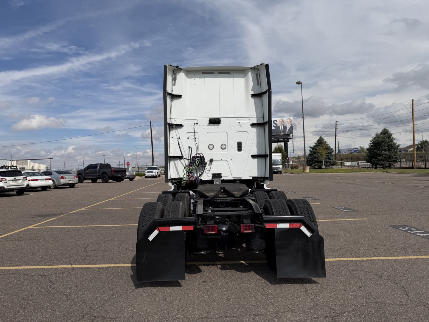 Truck tractor rear view showing International LT625 chassis and dual rear axles with mudflaps and high visibility lights.
