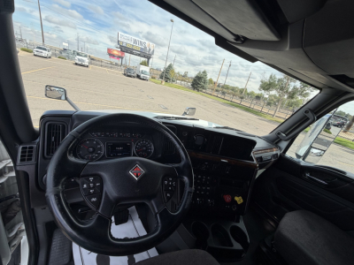 Truck cab interior of a 2019 International LT625 showing steering wheel, dashboard, and instrument cluster from the driver’s seat perspective.