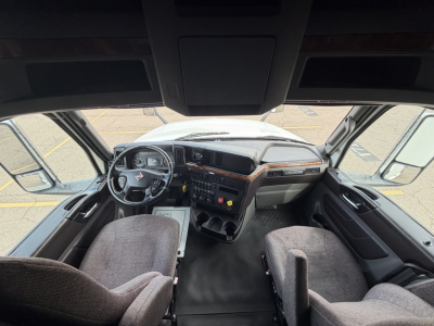 Interior cab view of a 2019 International LT625 sleeper tractor showing steering wheel, dashboard, and dash controls with gray fabric seats.