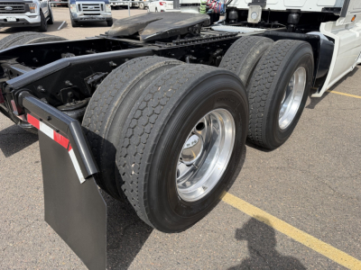 Triple rear axles of a 2019 International LT625 tractor showing dual rear tires and chrome wheels undercarriage and frame.