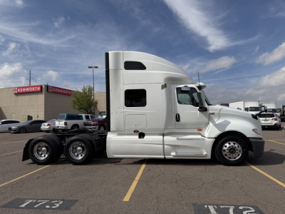 Truck side view showing 2019 International LT625 sleeper cab with white paint and dual rear axles.