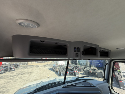 Front cabin ceiling and overhead console of a 2026 Mack GR64F roll-off truck showing interior panels and overhead compartments.