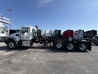 Mack GR64F rolloff truck side view showing long wheelbase, dual rear axles, and chassis with crane/haul bed. VIN 1M2GR4GC6TM053189 visible on listing; stock 70950.