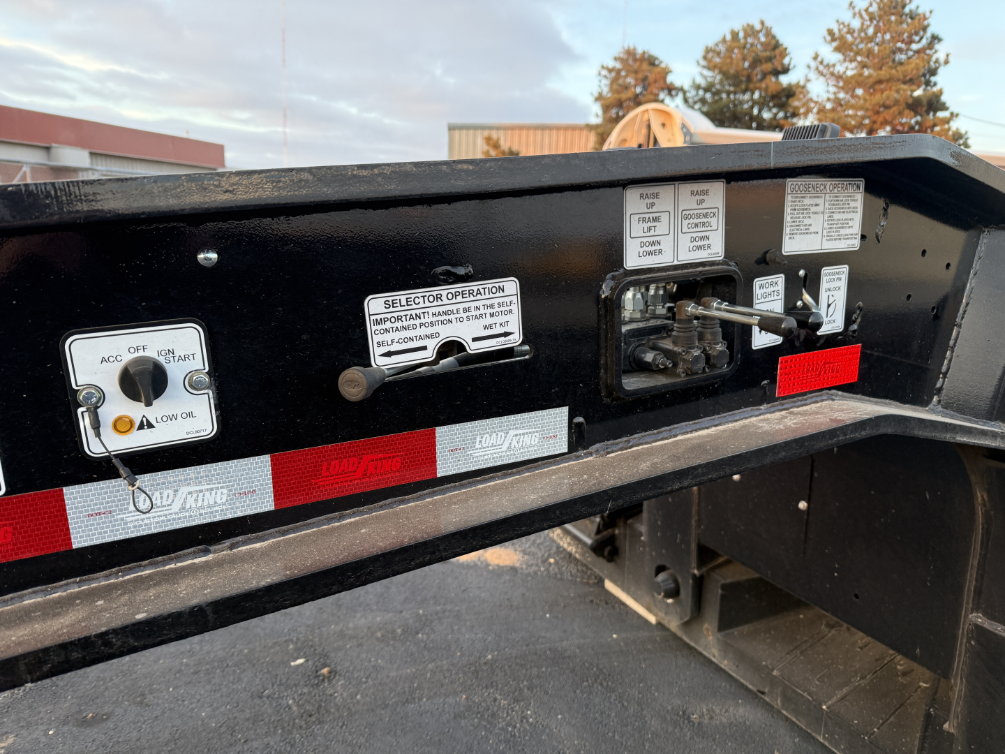 Load King trailer control panel and labels showing selector operations and safety instructions, with switches and gauge areas visible.