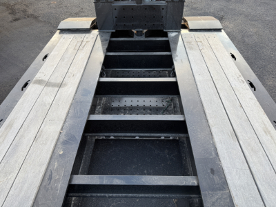 Trailer deck view of Load King trailer showing metal decking and support beams with wide, three-sectioned frame for a 9-foot wide lowboy.