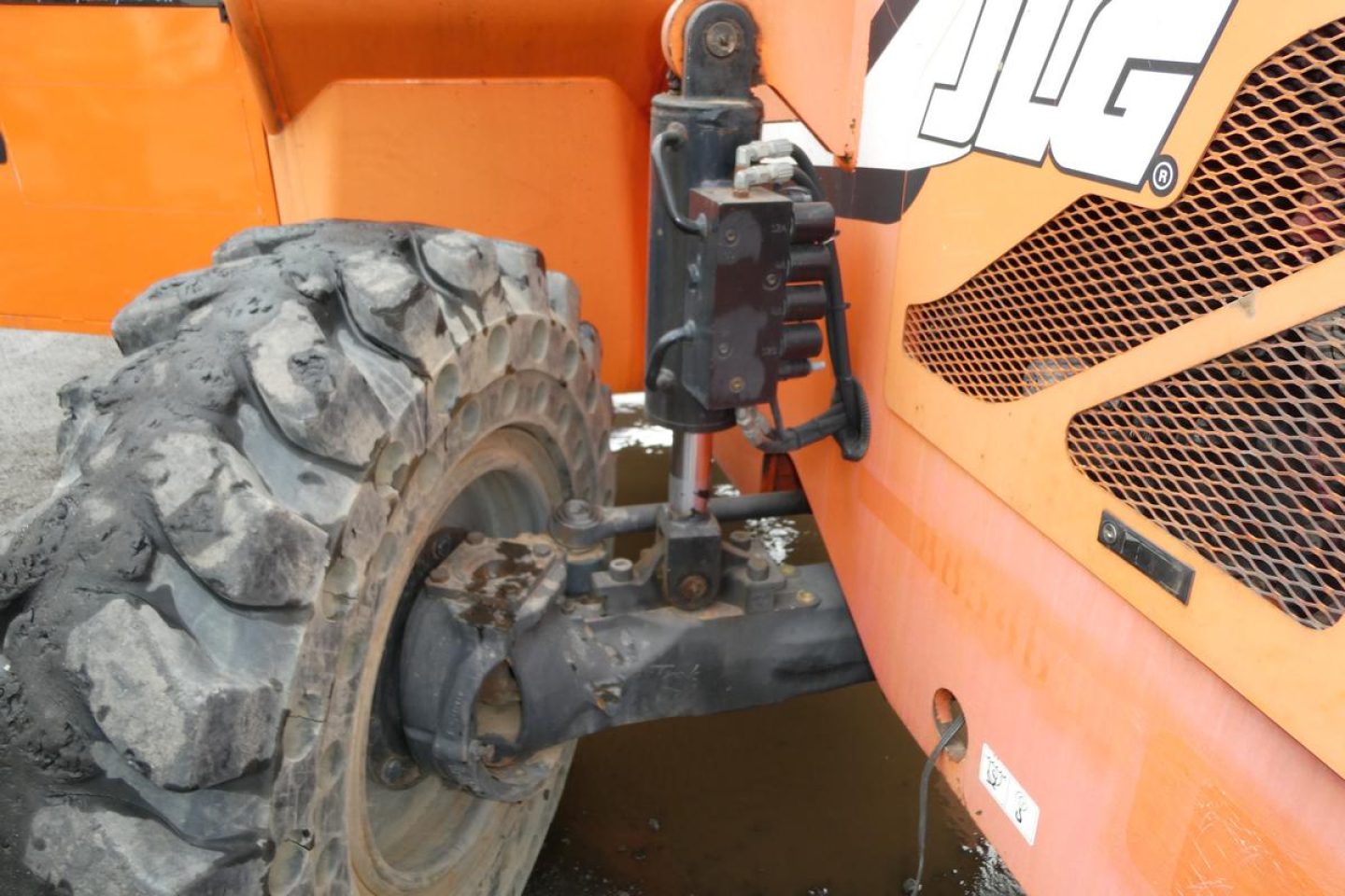JLG 6042 telescopic boom lift wheel and front suspension linkage visible