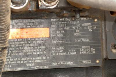 Close-up of engine identification plate on equipment, showing model and engine details including model EBHP, RPM, fuel rating, and displacement. Partial text visible near center: 'Important Engine Information', 'Model ESP3.HP? ', 'Displacem