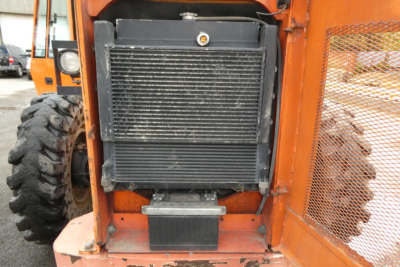Telescopic forklift radiator and front grill area visible; engine bay area with heavy equipment lines and welded frame.