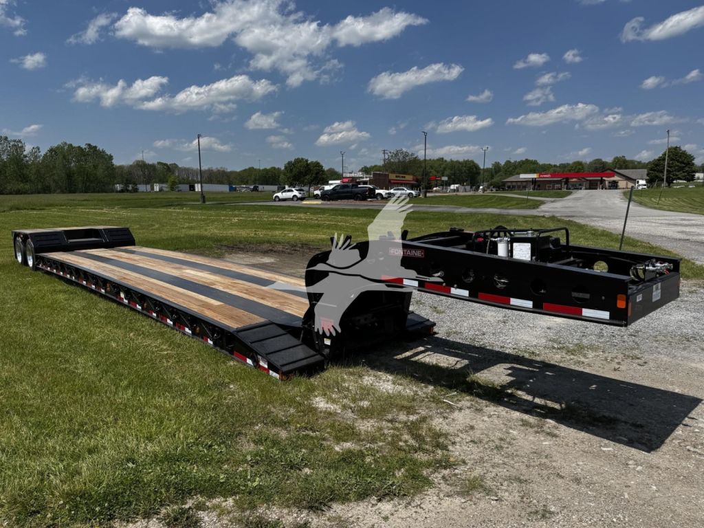Fontaine XN20 lowboy trailer in a parking lot showing long deck and gooseneck with black frame and wooden deck planks.