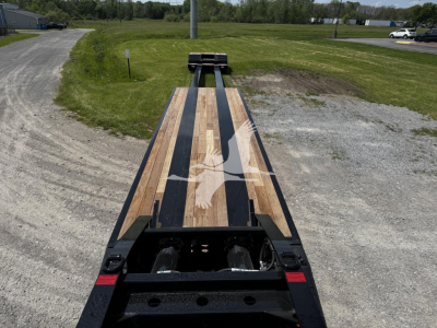 Flatbed trailer deck with wooden planks and black channel frame showing on a new Fontaine XN20 lowboy trailer.