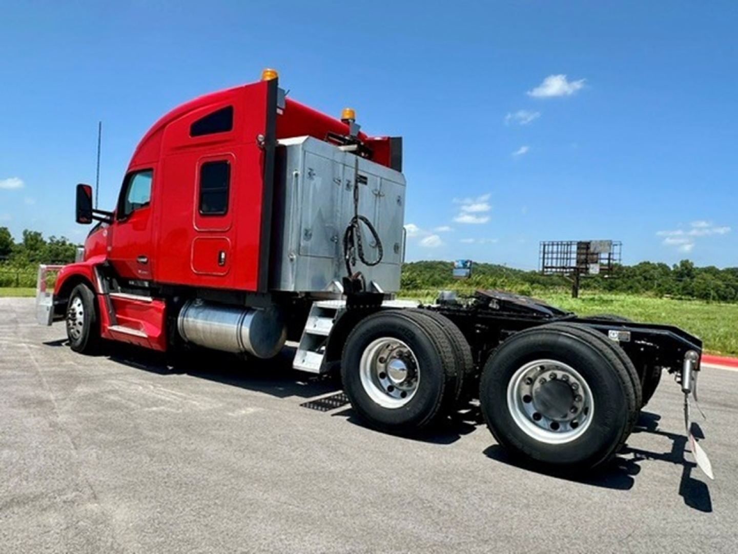 Kenworth T680 exterior view showing red sleeper cab and chassis with dual rear axles.