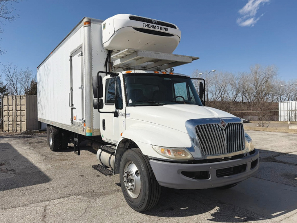 White 2016 International 4300 refrigerated truck with Thermo King unit on top, black grille, and side door, parked outdoors.