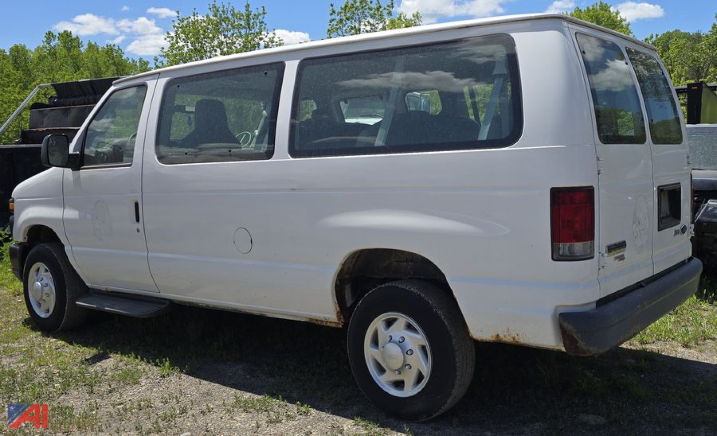 Ford E-350 XL Super Duty passenger van, 2011 model year, white, side and rear views visible with windows, basic body panels, rear bumper, and rims.