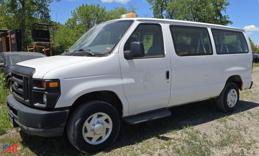 Ford E350 XL Super Duty van from 2011 side view showing passenger van with orange roof beacon and utility doors.