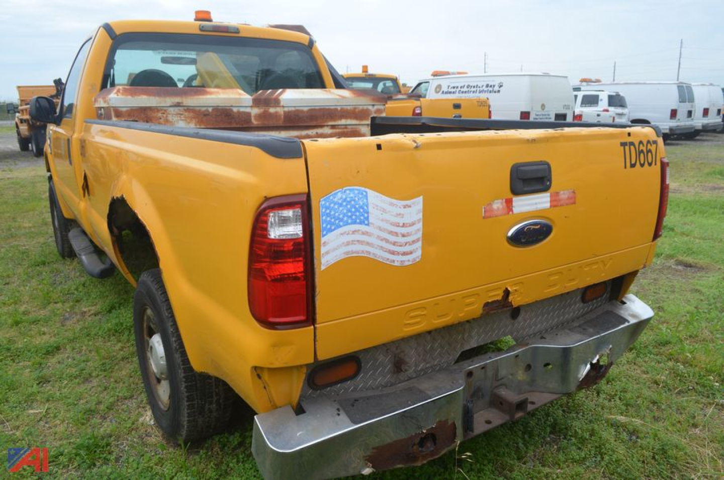 Ford F-250 Super Duty dump truck rear view showing yellow body, tailgate, and bumper with light wear.